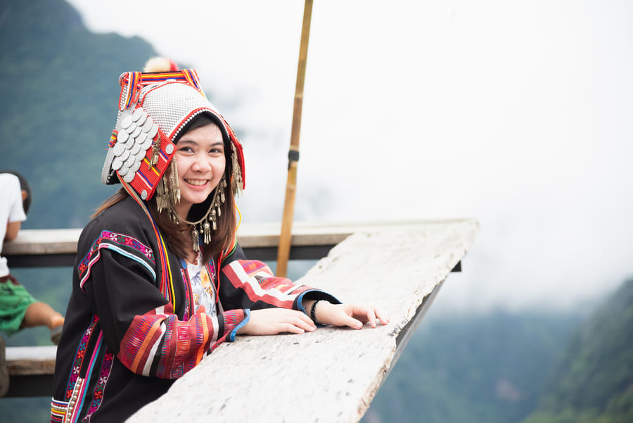 mujer vistiendo indumentaria tradicional de la etnia Hmong en china con un tocado adornado